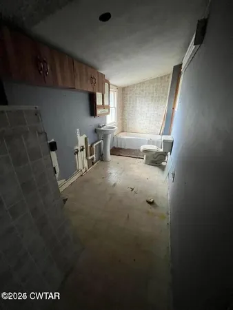 a room with water heater and wooden cabinets