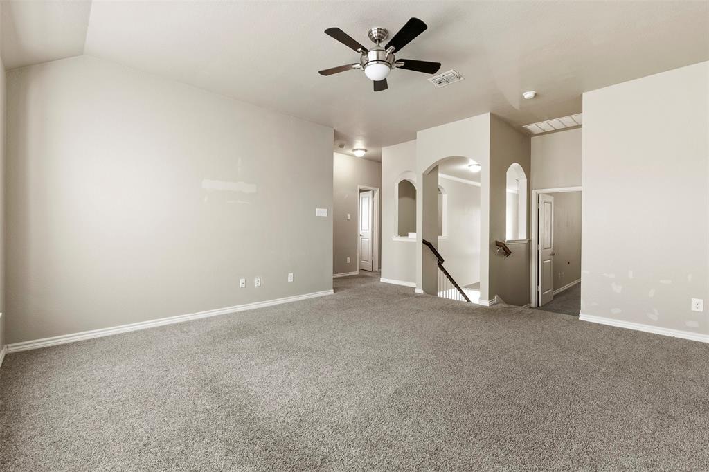 6522 Portside Ridge Lane Dallas, TX 75249 - Photo 18 of 37 Spacious carpeted room featuring a ceiling fan with integrated lighting, light-colored walls, white baseboards, and multiple arched doorways