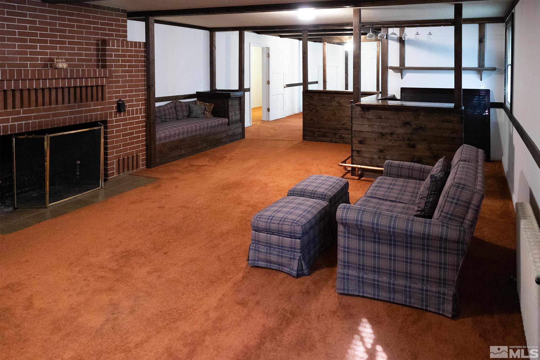 175 Mark Twain Avenue Reno, NV 89509 - Photo 22 of 27 a living room with furniture a fireplace and a flat screen tv
