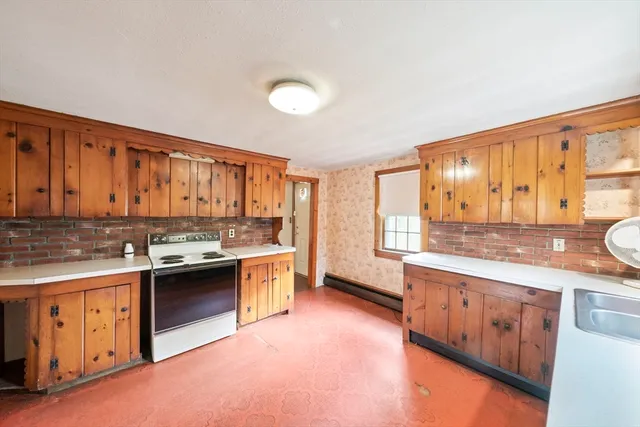 a large kitchen with stainless steel appliances granite countertop a stove sink and cabinets