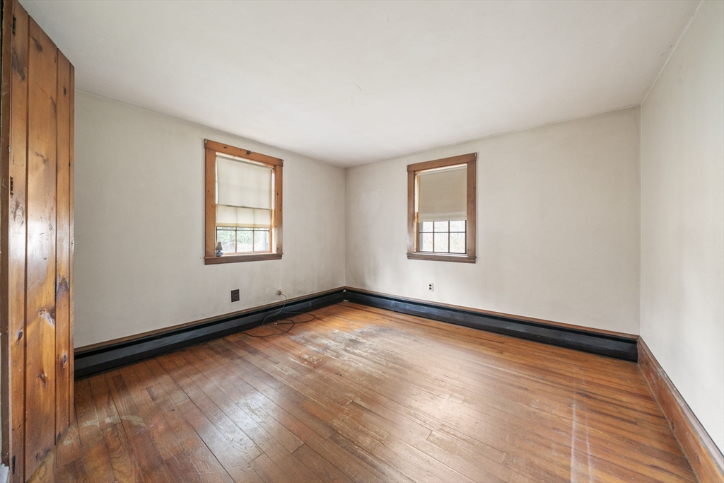 764 First Parish Road Scituate, MA 02066 - Photo 7 of 13 an empty room with wooden floor and windows