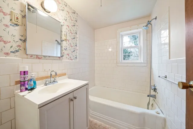 a bathroom with a sink vanity tub and shower