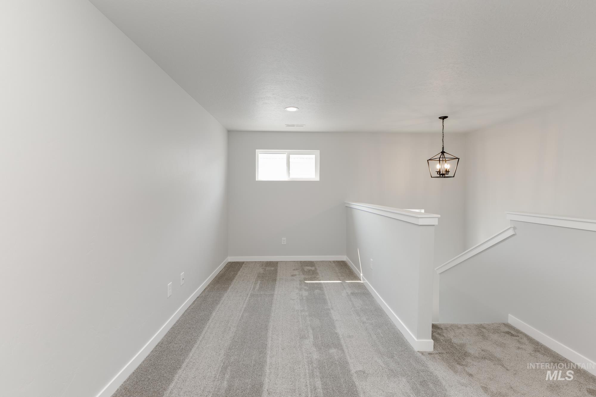16354 Backfill Avenue Caldwell, ID 83607 - Photo 14 of 25 Unfurnished room featuring light carpet and a chandelier