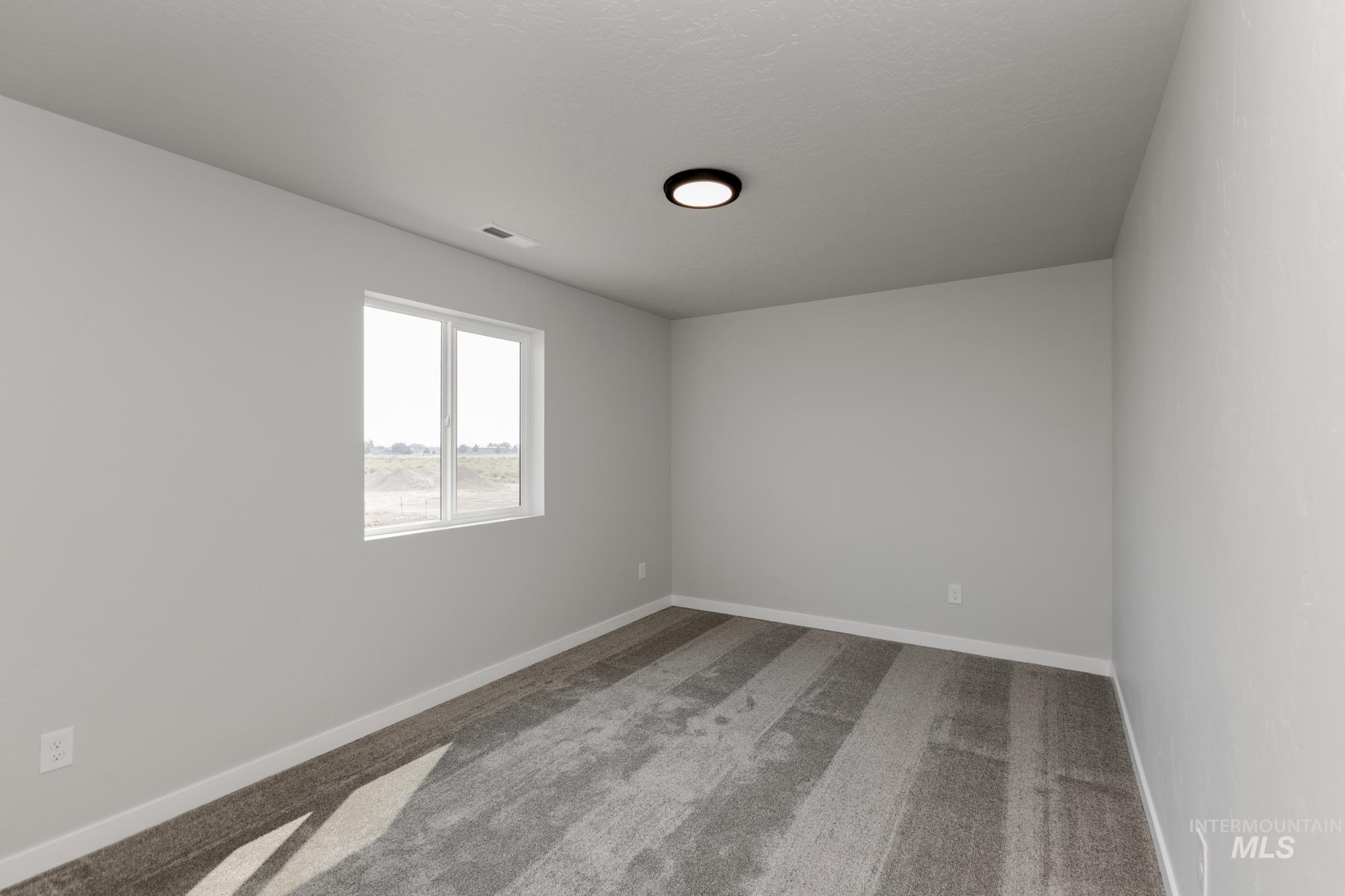 16354 Backfill Avenue Caldwell, ID 83607 - Photo 15 of 25 Spare room with light colored carpet and baseboards