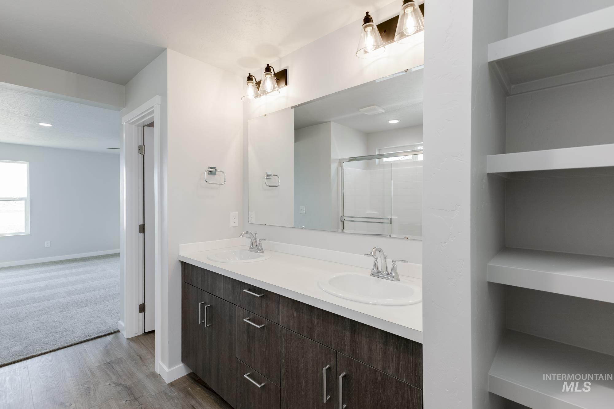 16354 Backfill Avenue Caldwell, ID 83607 - Photo 23 of 25 Bathroom with double vanity, wood finished floors, and a stall shower
