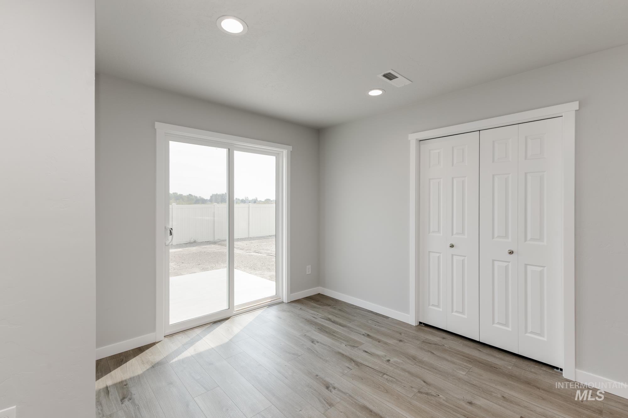 16354 Backfill Avenue Caldwell, ID 83607 - Photo 7 of 25 Unfurnished bedroom with light wood-style flooring, recessed lighting, access to outside, and a closet