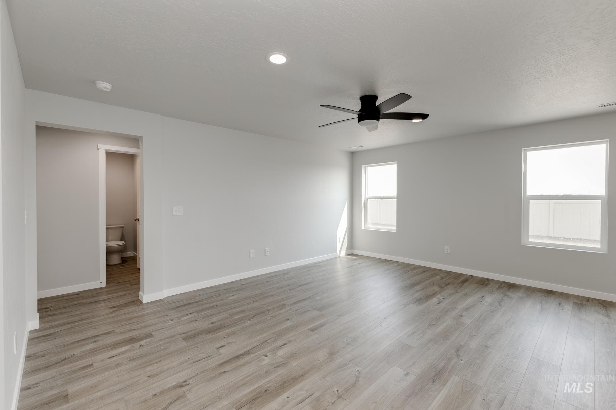16354 Backfill Avenue Caldwell, ID 83607 - Photo 8 of 25 Unfurnished room featuring healthy amount of natural light, light wood-style floors, recessed lighting, and a ceiling fan