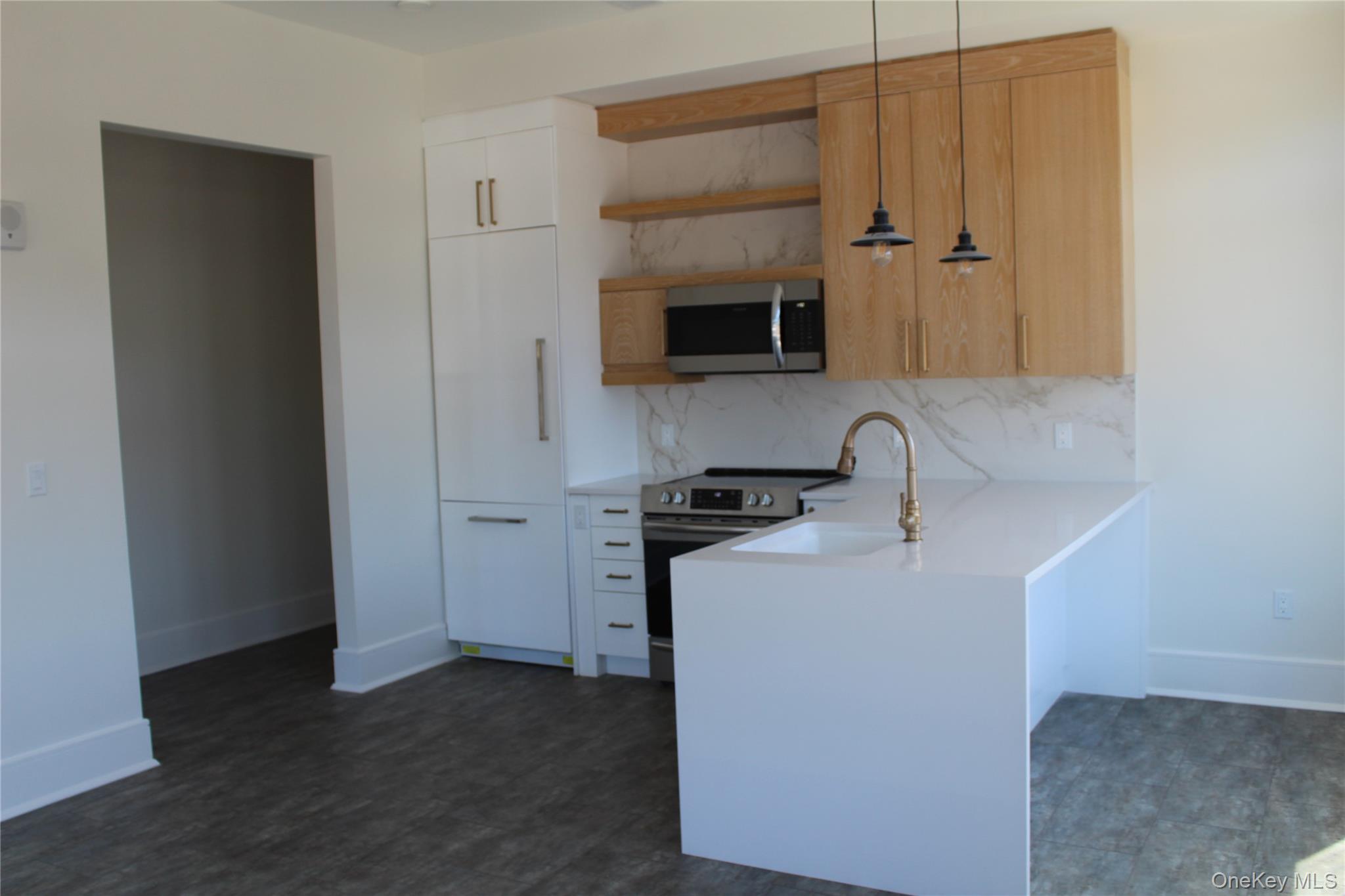 331 East Main Street, Unit 204 Riverhead, NY 11901 - Photo 2 of 5 a kitchen with stainless steel appliances a sink and a refrigerator