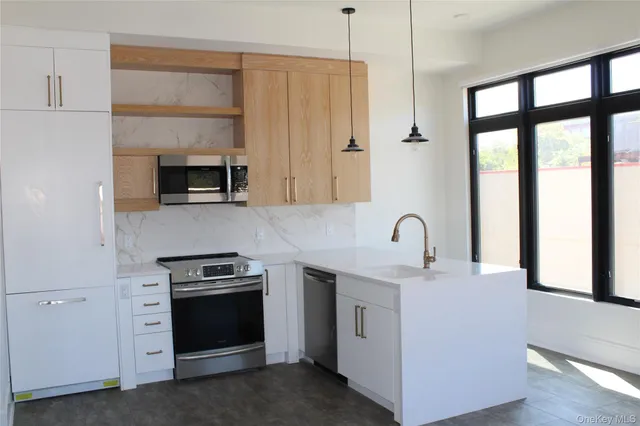 a kitchen with stainless steel appliances a stove microwave and sink