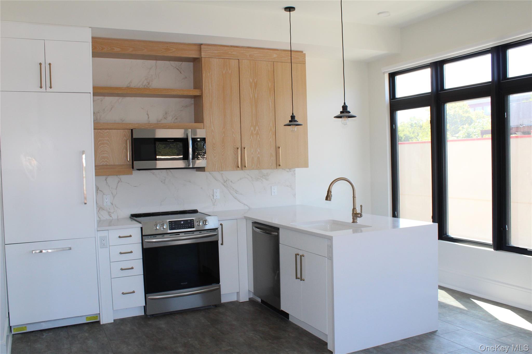 331 East Main Street, Unit 204 Riverhead, NY 11901 - Photo 3 of 5 a kitchen with stainless steel appliances a stove microwave and sink