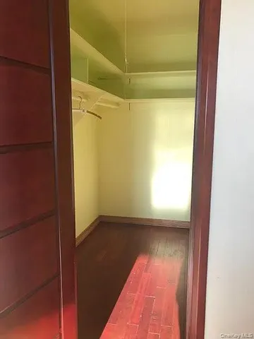 a view of a room with wooden floor and a window