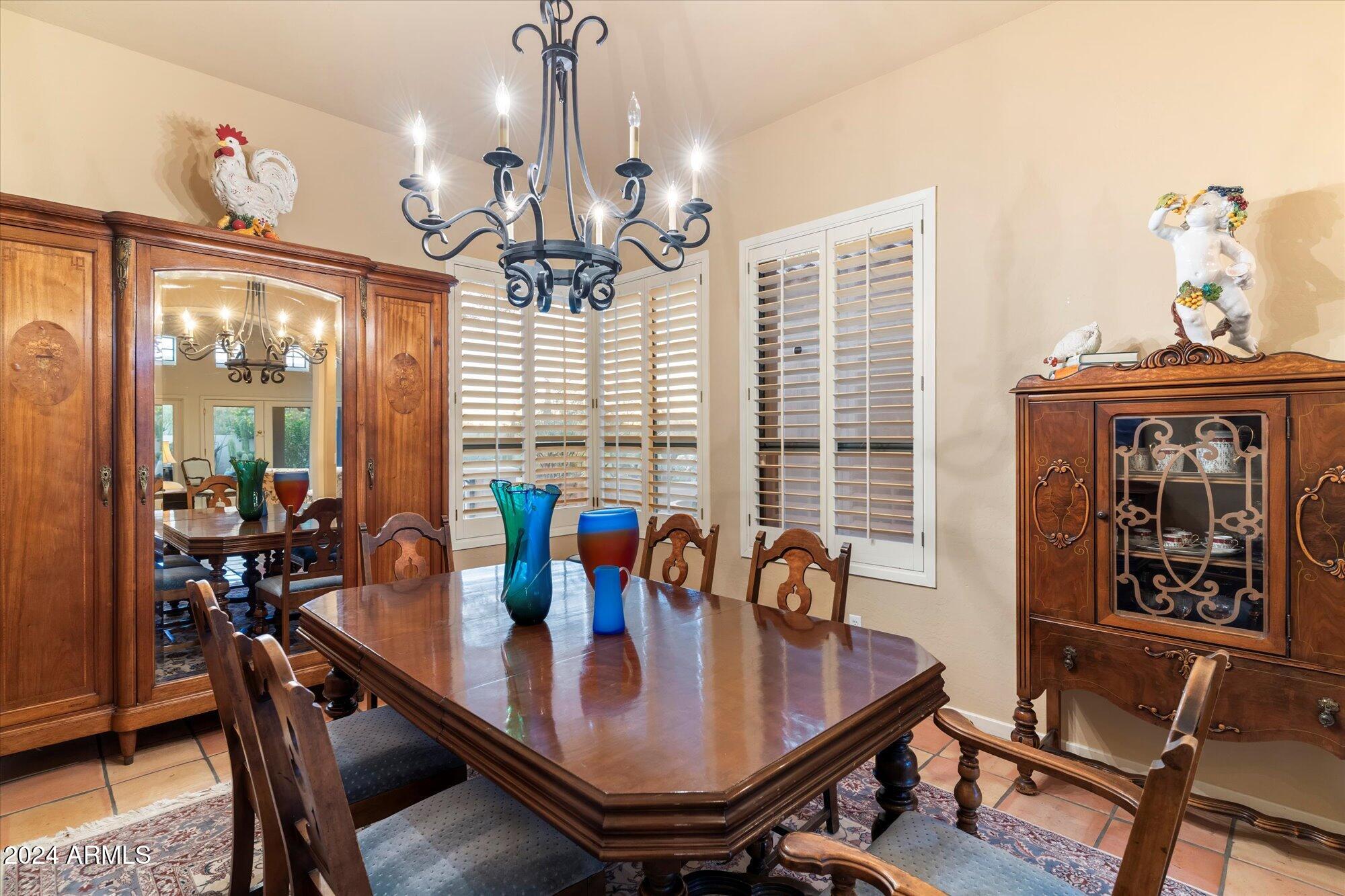25255 North Ranch Gate Road Scottsdale, AZ 85255 - Photo 16 of 68 a dining room with furniture a chandelier and wooden floor