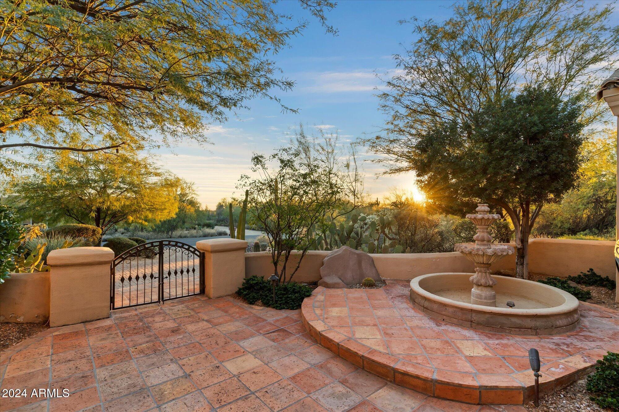 25255 North Ranch Gate Road Scottsdale, AZ 85255 - Photo 5 of 68 a view of a patio with table and chairs potted plants and large tree