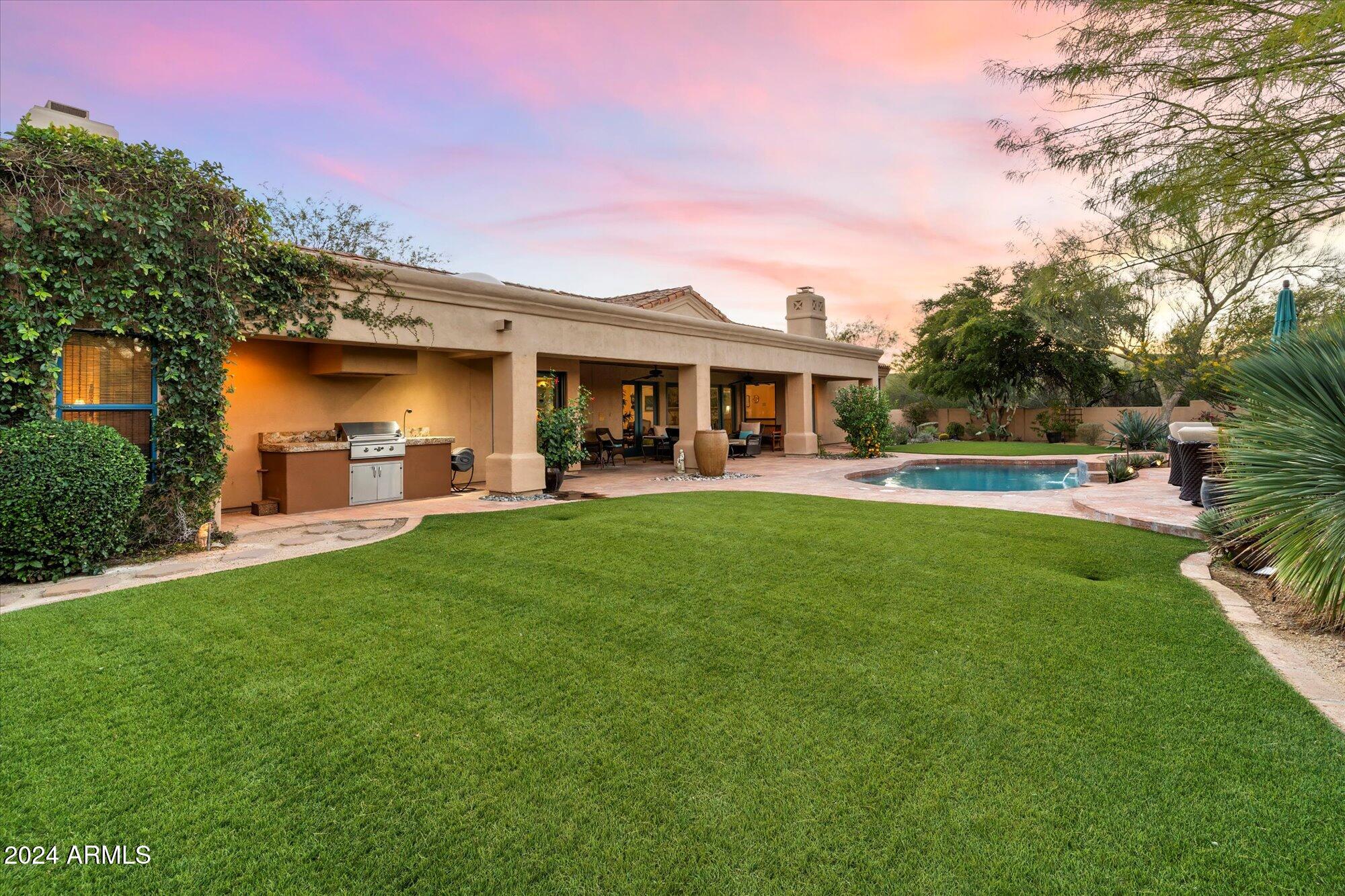 25255 North Ranch Gate Road Scottsdale, AZ 85255 - Photo 61 of 68 a front view of a house with a yard table and chairs