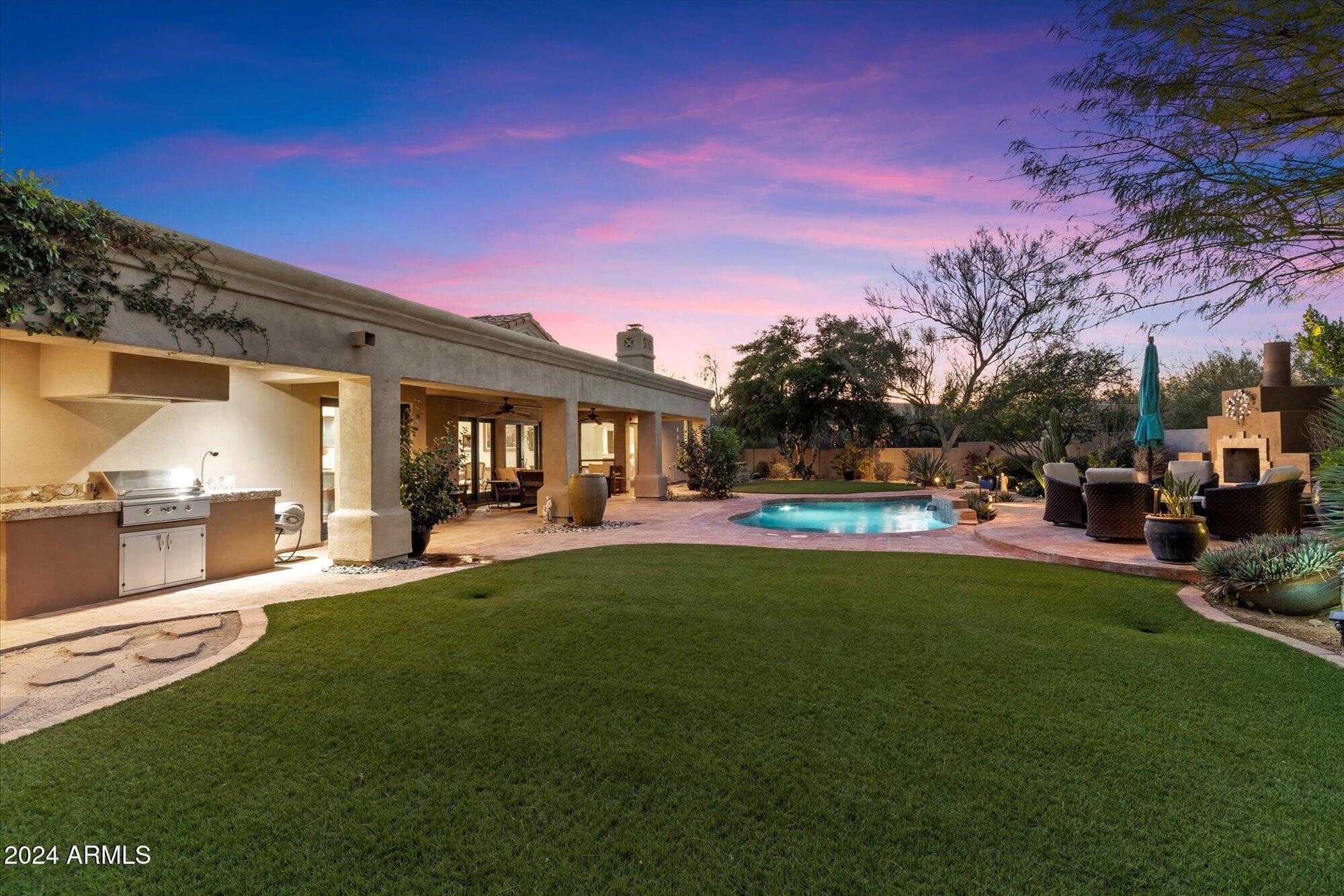 25255 North Ranch Gate Road Scottsdale, AZ 85255 - Photo 66 of 68 a front view of a house with a garden