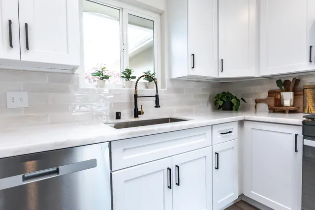 a kitchen with stainless steel appliances white cabinets and a stove top oven