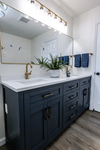 a bathroom with a granite countertop sink a toilet and mirror