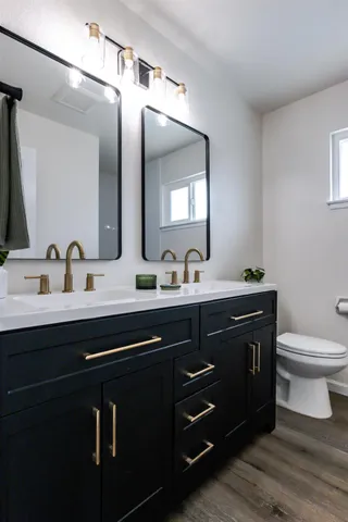 a bathroom with a toilet a sink and mirror