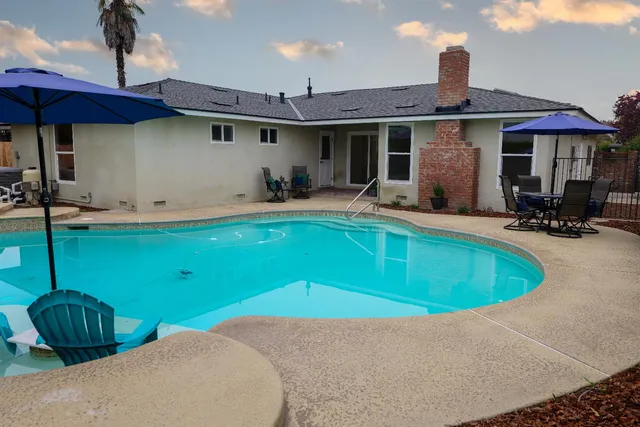 a view of a patio with a table and chairs under an umbrella