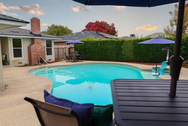 a patio with table and chairs under an umbrella