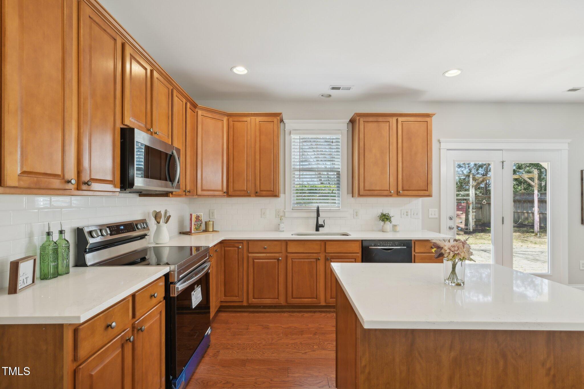 304 Frontgate Drive Cary, NC 27519 - Photo 12 of 41 a kitchen with stainless steel appliances granite countertop a sink stove and microwave