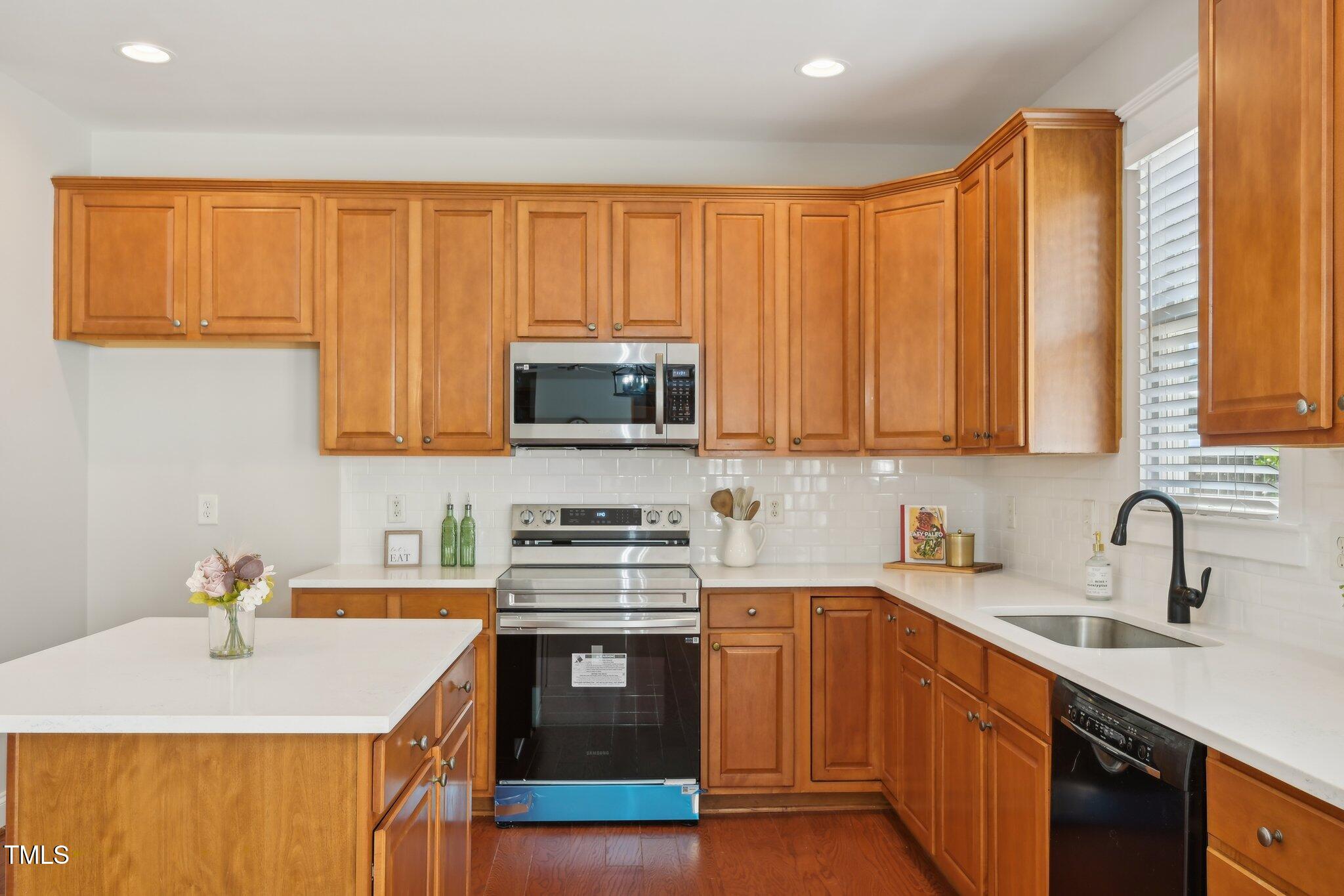 304 Frontgate Drive Cary, NC 27519 - Photo 15 of 41 a kitchen with stainless steel appliances granite countertop a sink a stove a microwave oven with cabinets and wooden floor