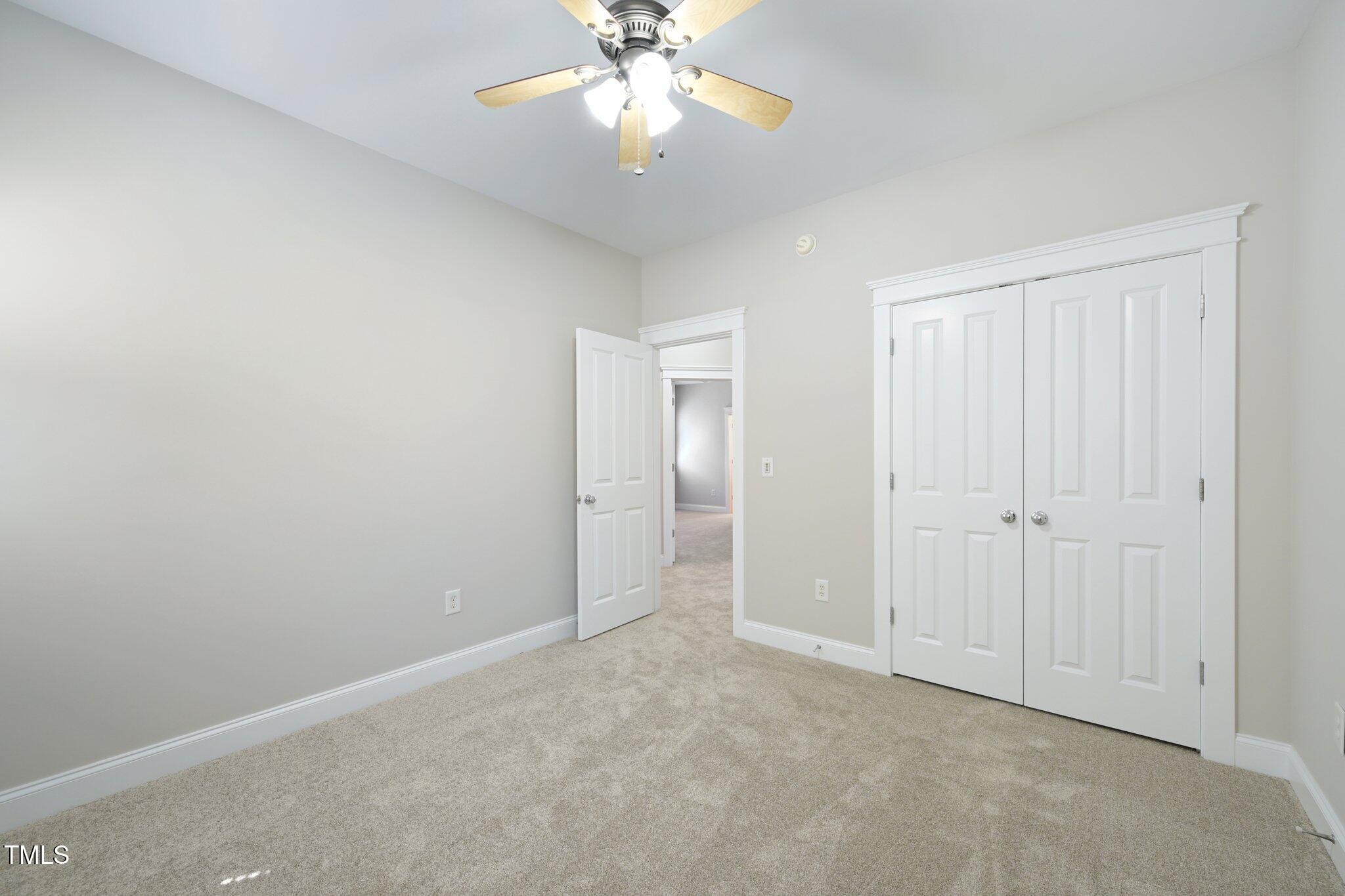 304 Frontgate Drive Cary, NC 27519 - Photo 27 of 41 an empty room with a chandelier fan and windows