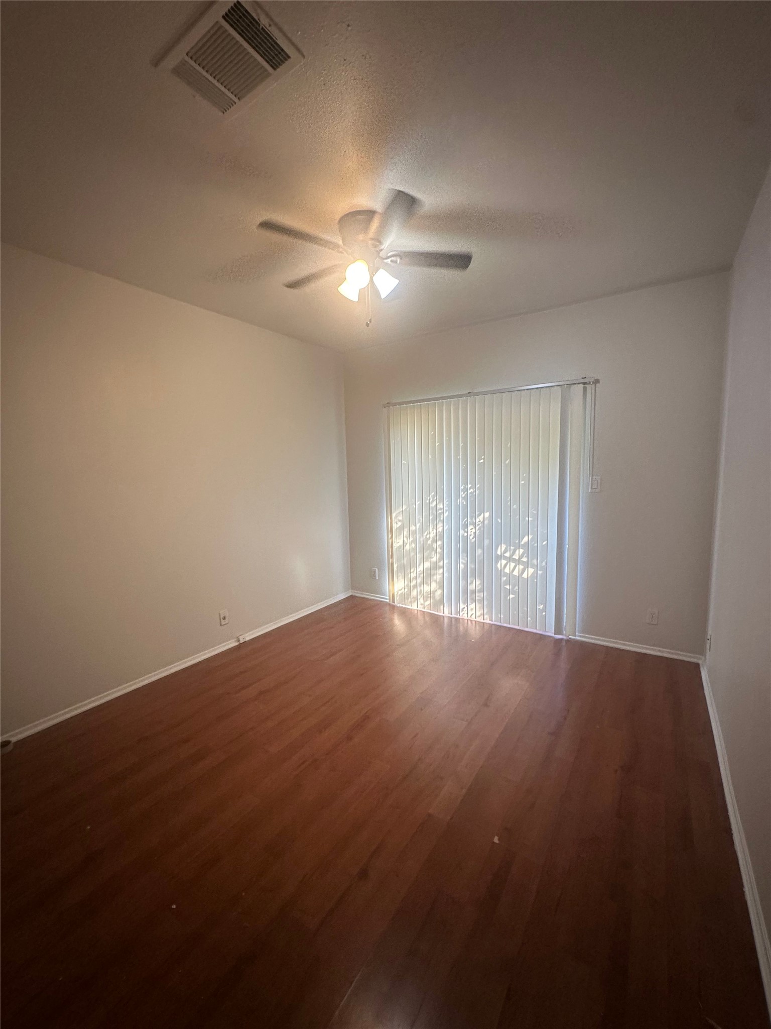 106 East 30th Street, Unit 101 Austin, TX 78705 - Photo 8 of 11 Spare room featuring dark wood-style flooring, ceiling fan, and a textured ceiling