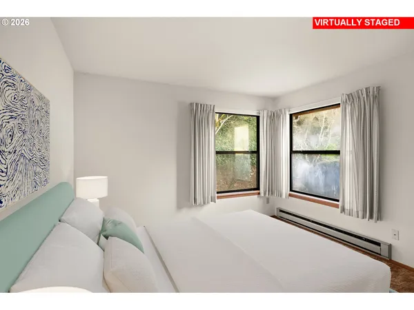 a bedroom with a bed and a large window