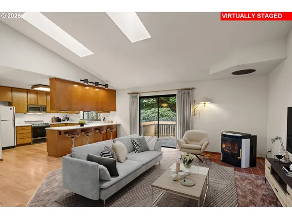 a living room with furniture kitchen view and a window