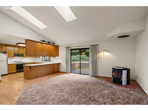 a kitchen with stainless steel appliances kitchen island granite countertop a sink counter space and a window