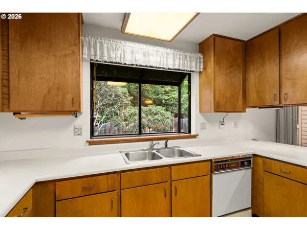 a kitchen with a sink a window and cabinets