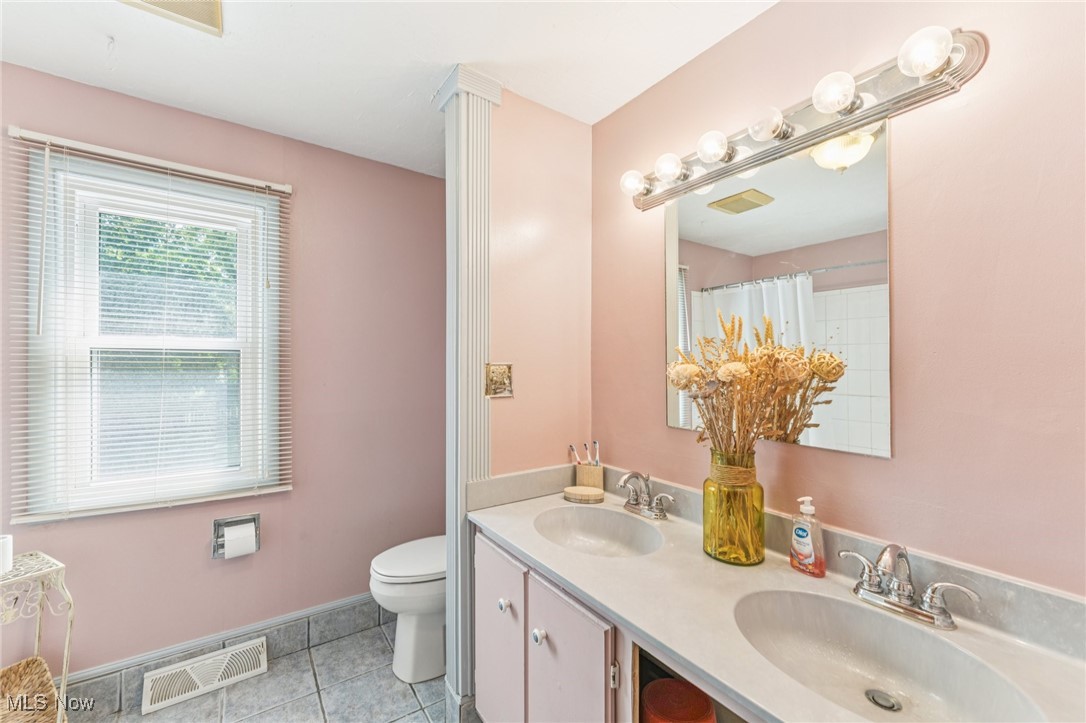 2911 Lee Road Cleveland, OH 44120 - Photo 28 of 50 Bathroom with light tile patterned floors, double vanity, and curtained shower