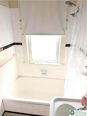 a bathroom with a bathtub and a window