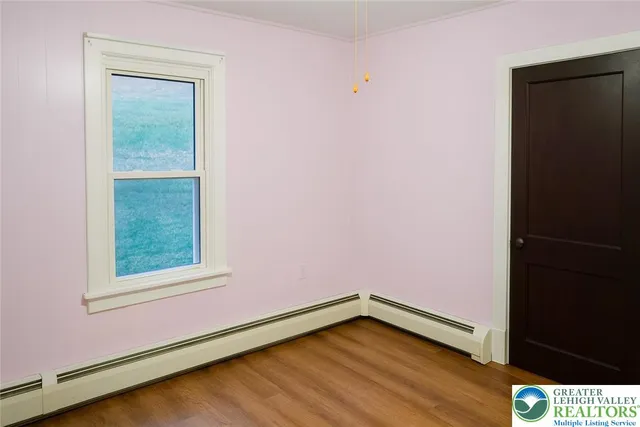 a view of a small space with wooden floor and a window