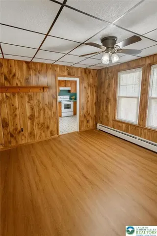 en empty room with wooden floor and windows