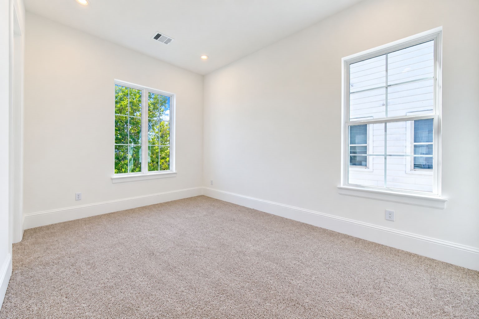 2309 Hollister Road Houston, TX 77080 - Photo 28 of 47 Bright and inviting secondary bedroom offers generous proportions, plush carpeting, and multiple windows that fill the space with natural light. The soft neutral palette provides a sophisticated blank canvas for guests, family, or a stylish home office, while maintaining the refined aesthetic found throughout the home.