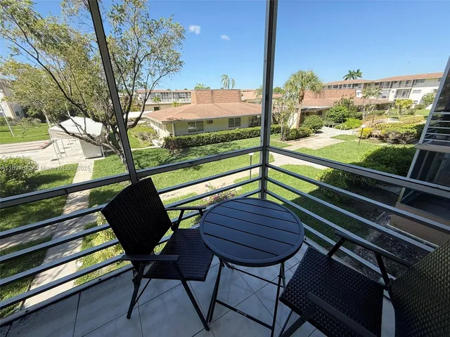 a view of a chairs and table on the balcony