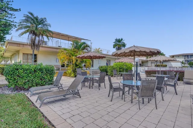 a view of a patio with a table and chairs under an umbrella