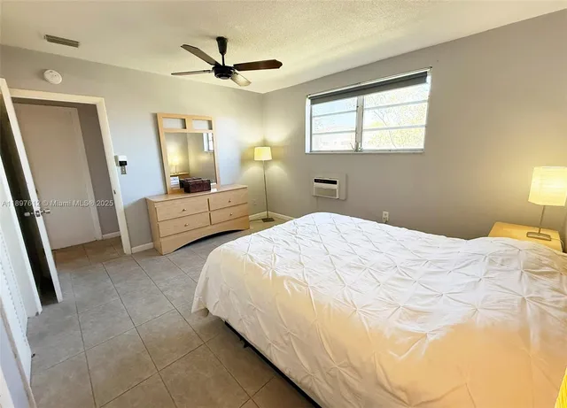 a bedroom with a bed mirror and a window