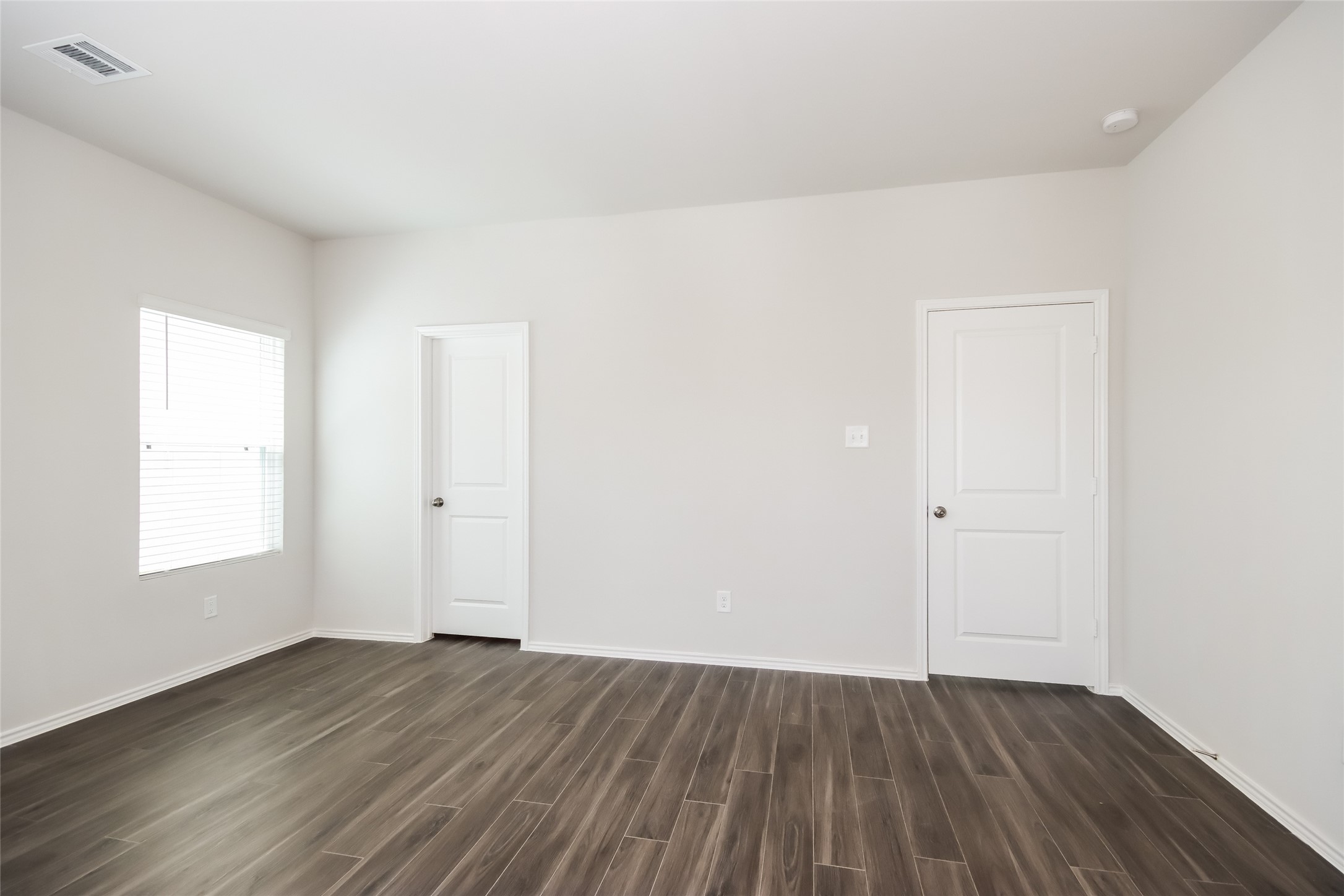 15264 Estrella Road East Houston, TX 77073 - Photo 9 of 14 an empty room with wooden floor and windows