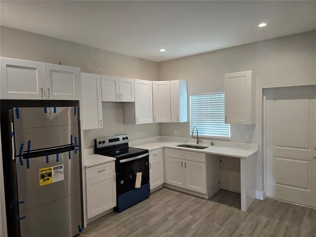 a kitchen with a sink a refrigerator and cabinets