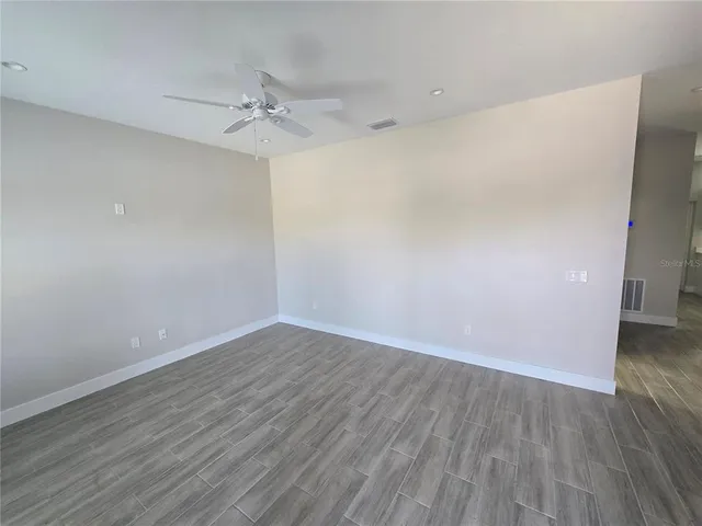a view of an empty room with wooden floor