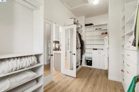 a living room with furniture floor to ceiling window hardwood floor and a flat screen tv