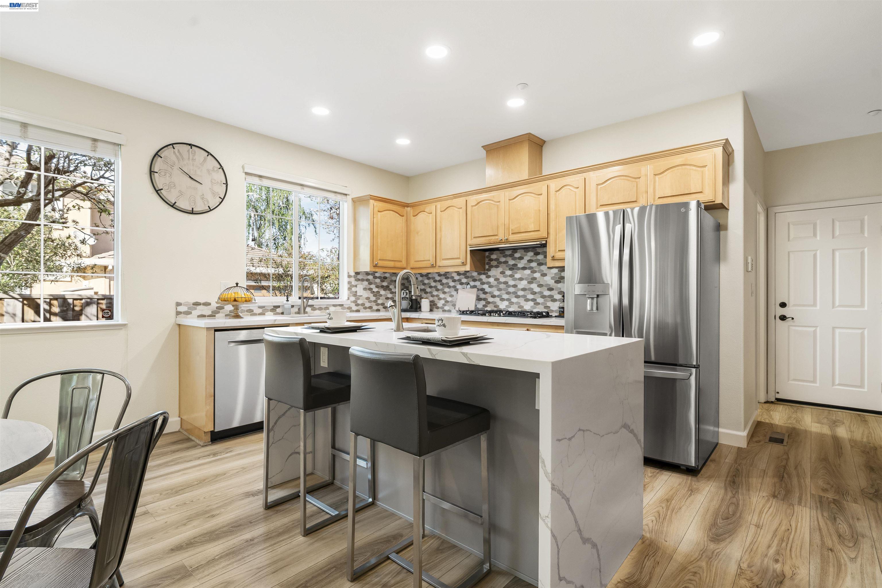 1635 Embassy Circle Livermore, CA 94550 - Photo 33 of 60 a kitchen with stainless steel appliances granite countertop a stove a refrigerator a sink a dining table and chairs with wooden floor