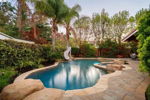 a view of swimming pool with outdoor seating and a patio