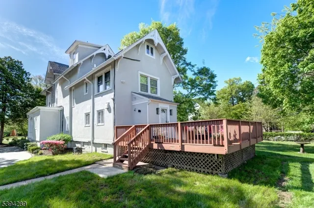 a view of a house with a yard and deck