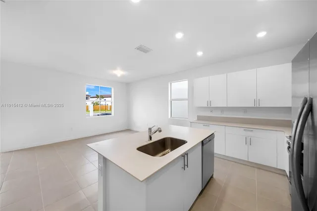 a kitchen that has a sink a stove and cabinets