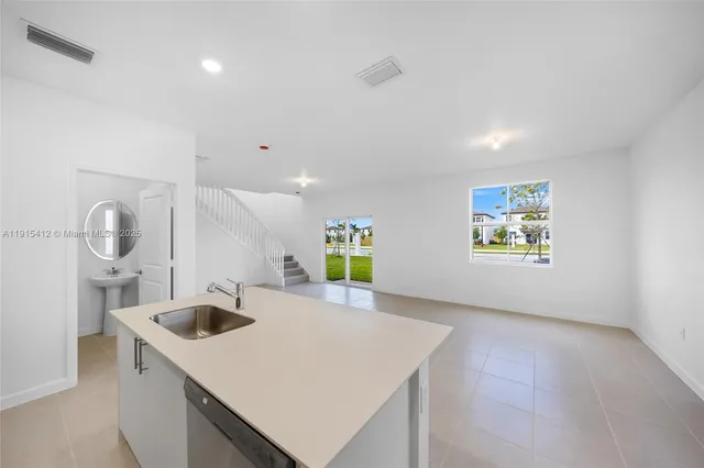 a kitchen with a sink a stove and cabinets