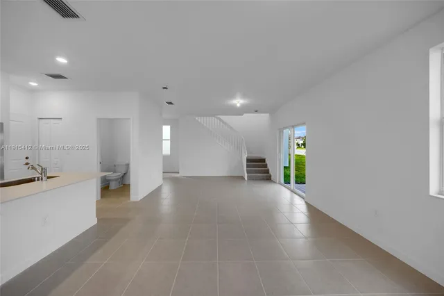 a view of a big room with wooden floor and windows